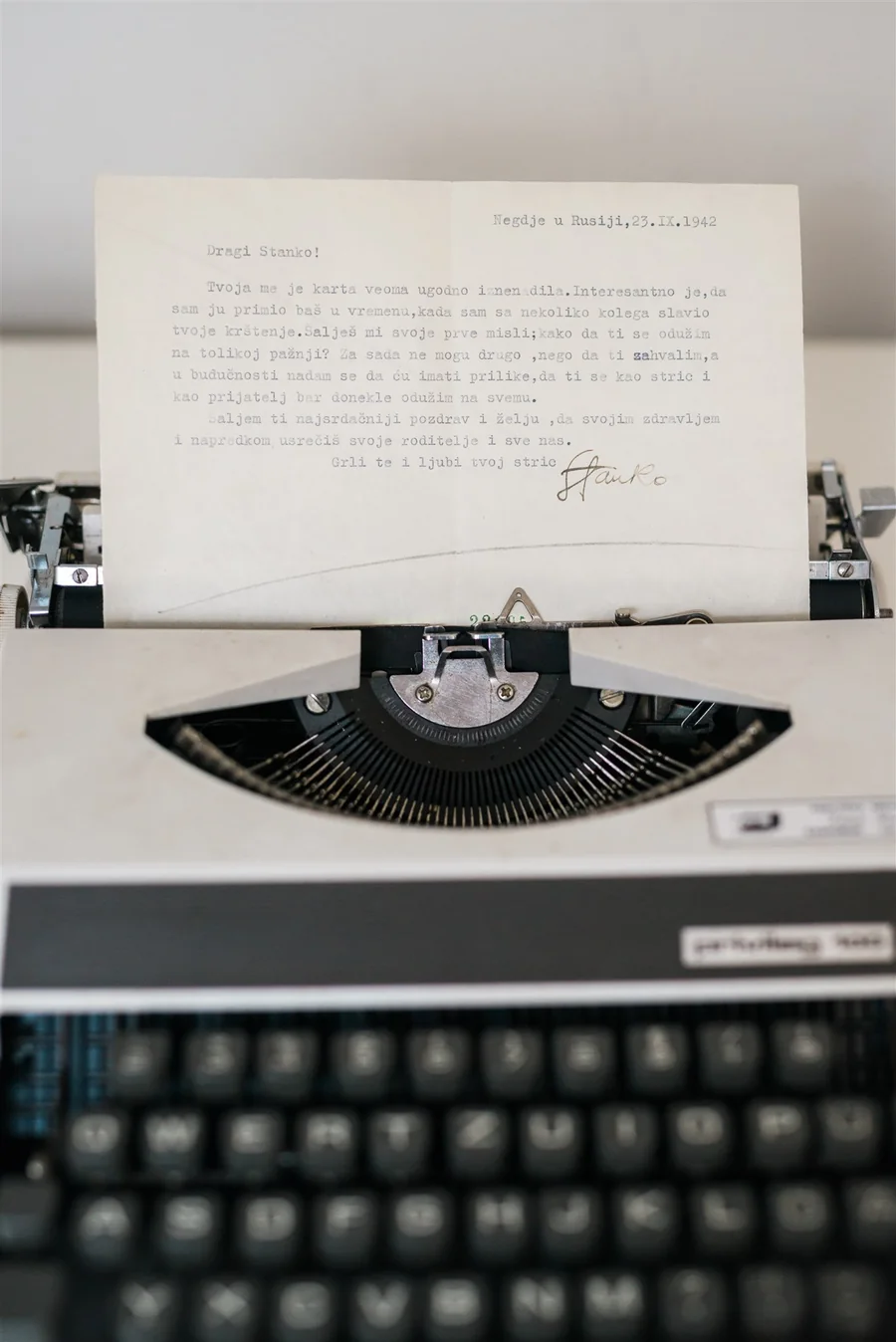 An old letter in a typewriter — the Root of Joy welcome letter