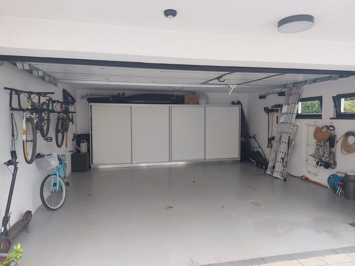 The same garage after organizing — bikes and tools on the wall, the floor clear