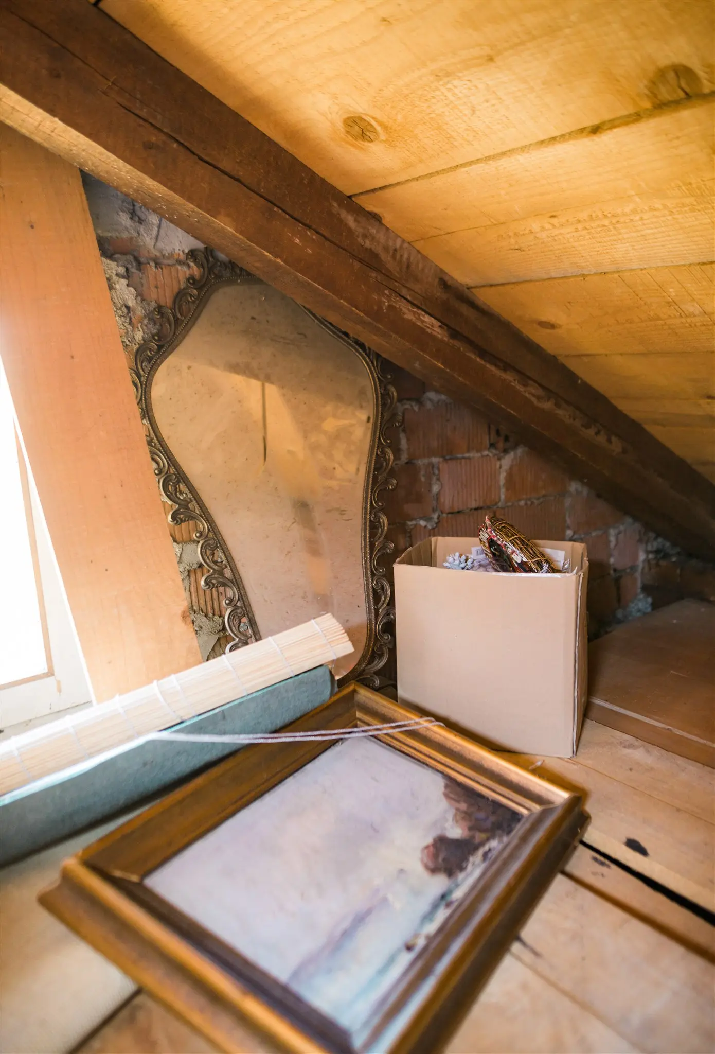 Framed pictures, a mirror and boxes in an attic before donation pickup — items still worth passing on, Zagreb