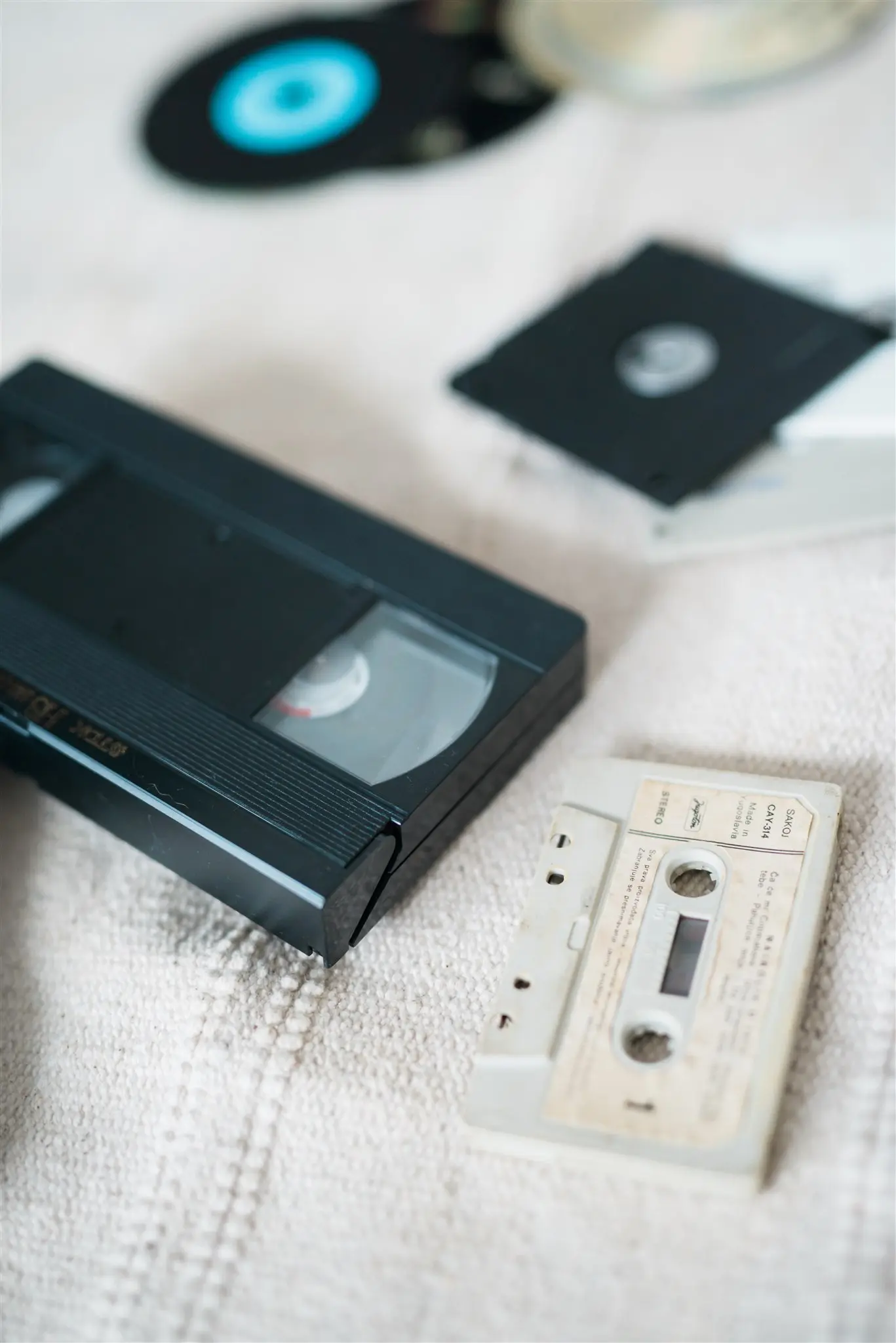 Close-up of a VHS tape and an audio cassette — fragile formats that deteriorate with age