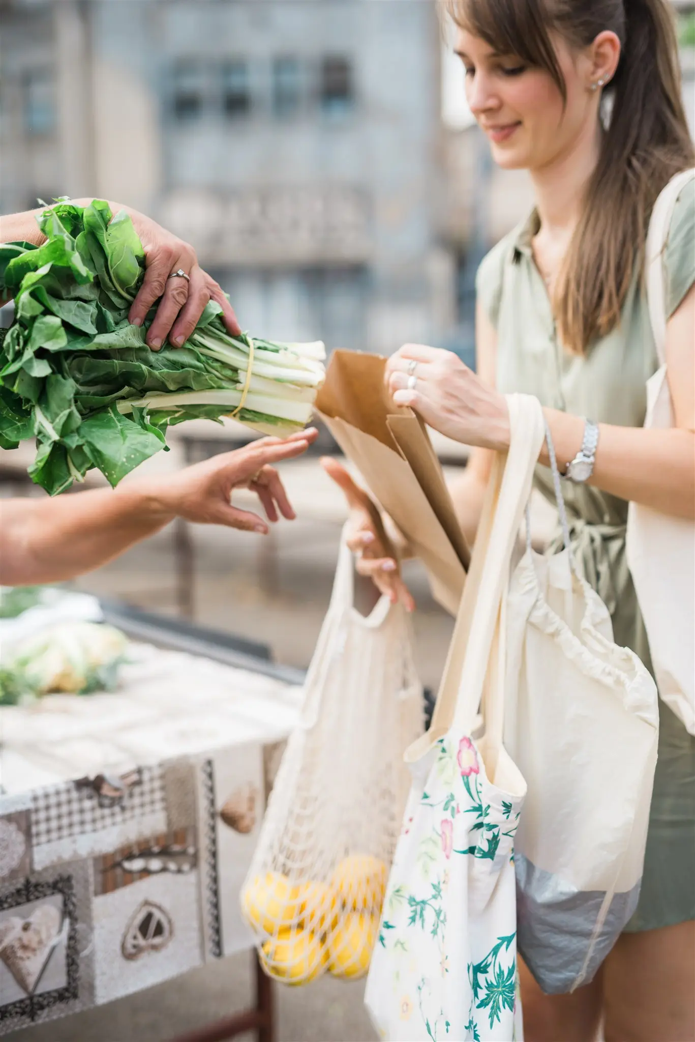 Buying vegetables into cloth and mesh bags at a market stall — packaging-free shopping in Zagreb
