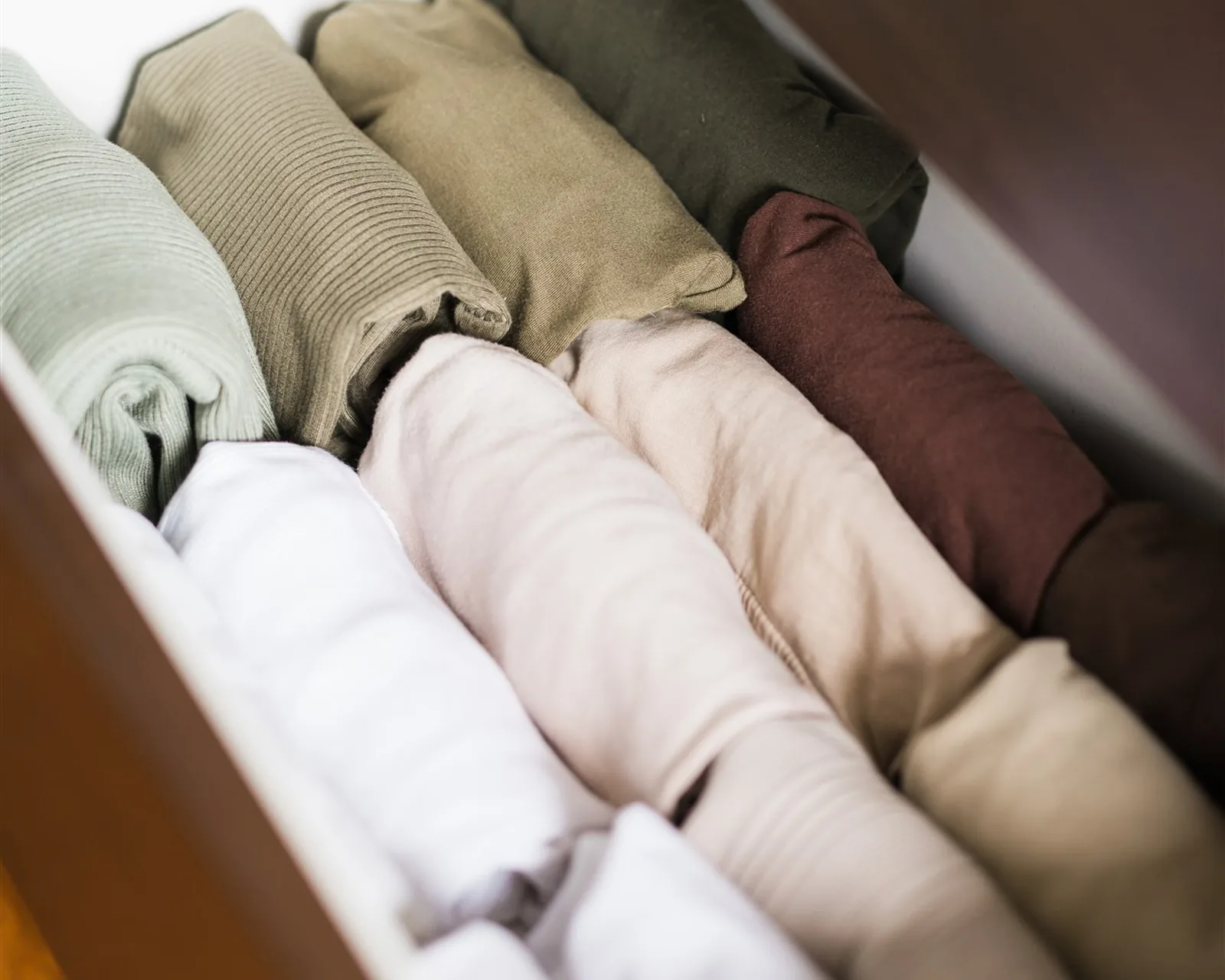 T-shirts and jumpers folded upright in a drawer — the KonMari way of folding clothes