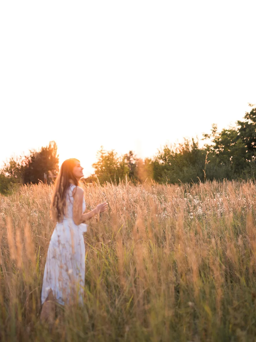 Petra Pupić in a white dress walking through tall grass at sunset &mdash; living with less waste
